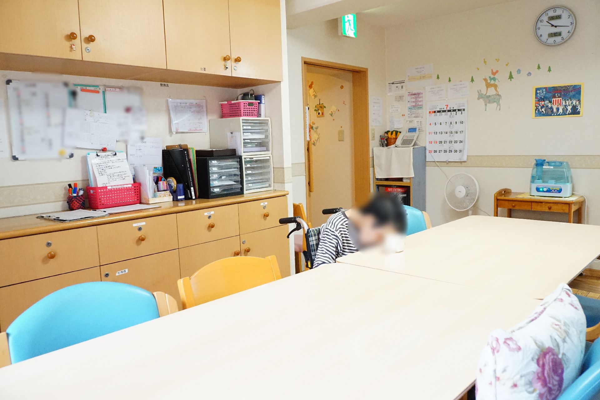 テーブルを挟んで椅子が置かれ、入居者が思い思いに時間を過ごしているリビング