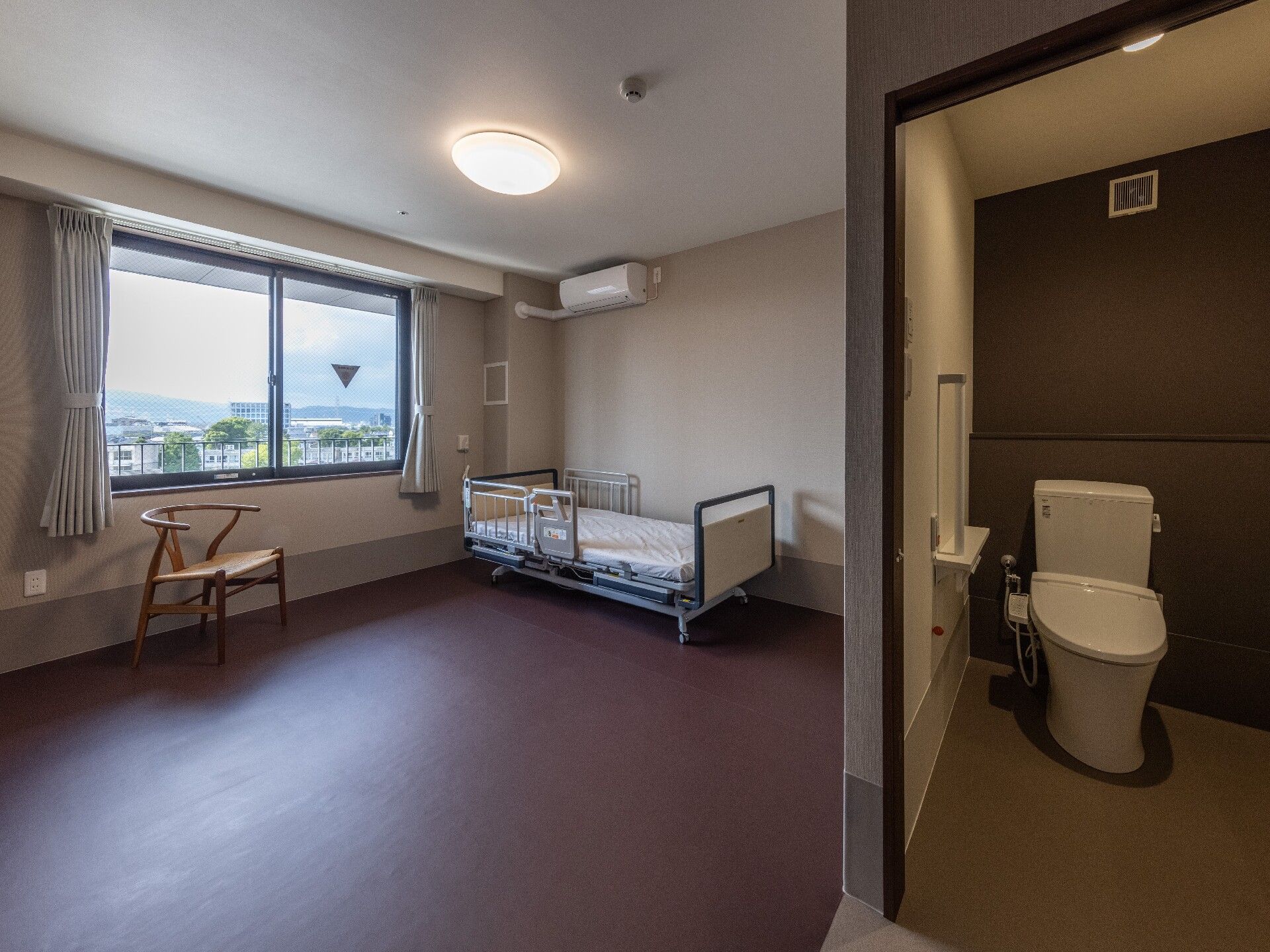 ベッドが配置されたエアコンとトイレを完備した居室