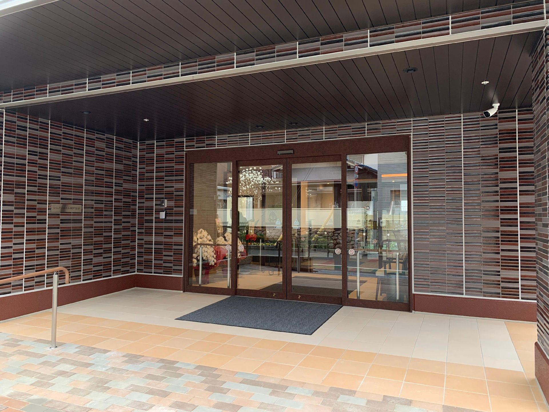 3階建ての建物はすっきりとしたスタイリッシュな外観で、建物周辺にはフェンスもあり、ベランダも付いている。