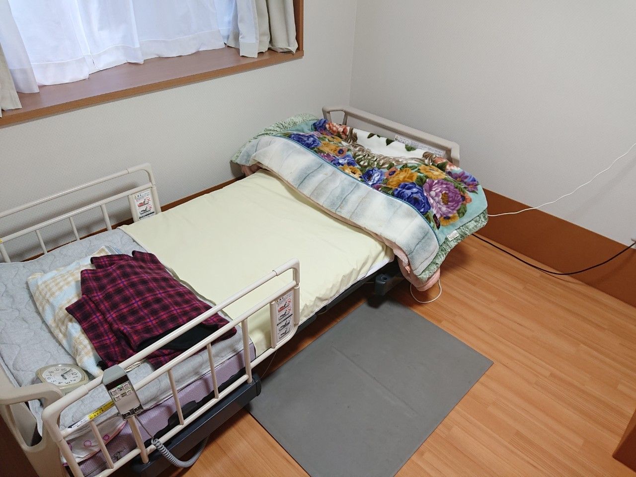 布団には毛布や目覚まし時計が置かれている