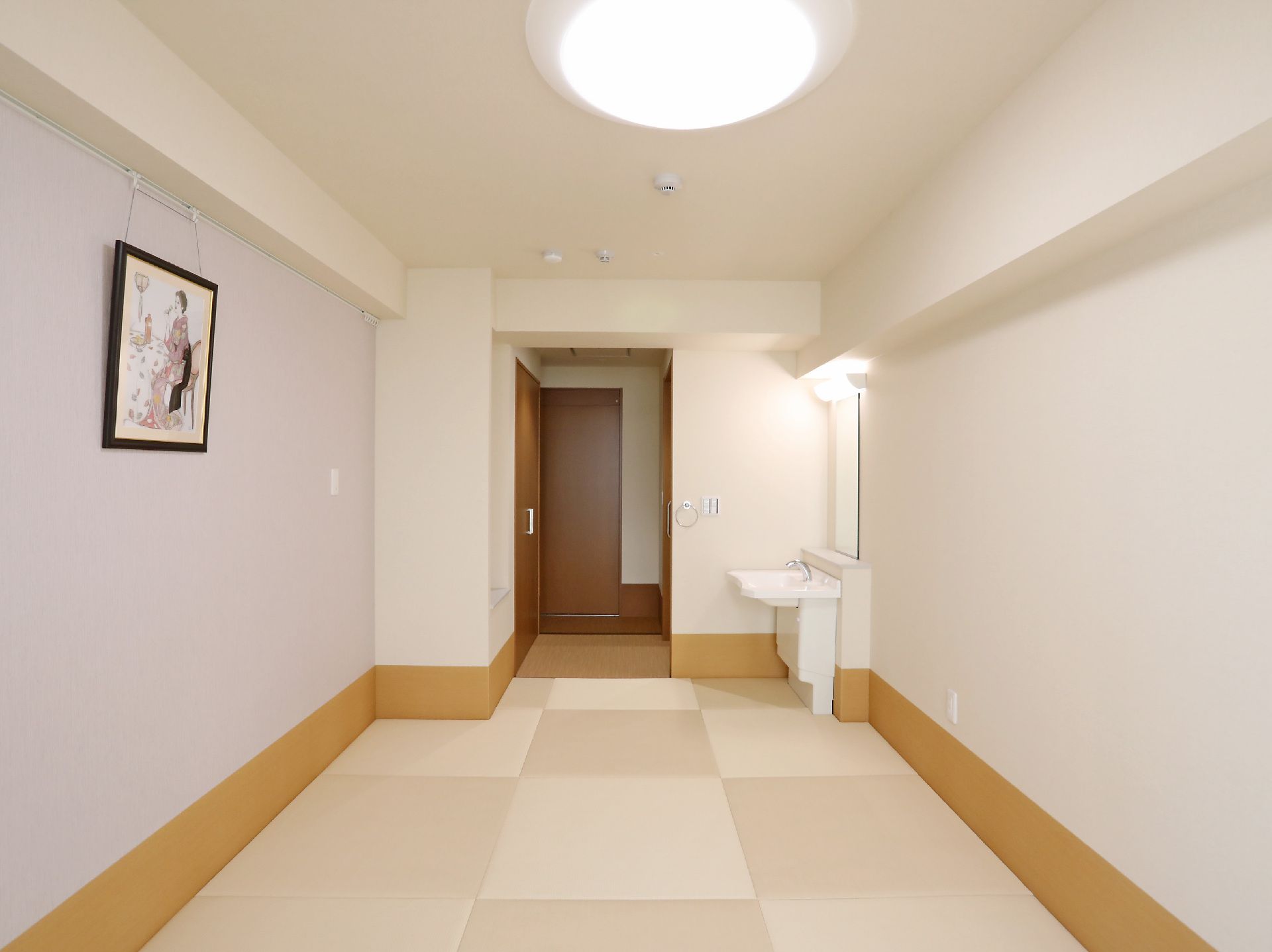 洗面台が設置され壁に絵画が飾られた居室
