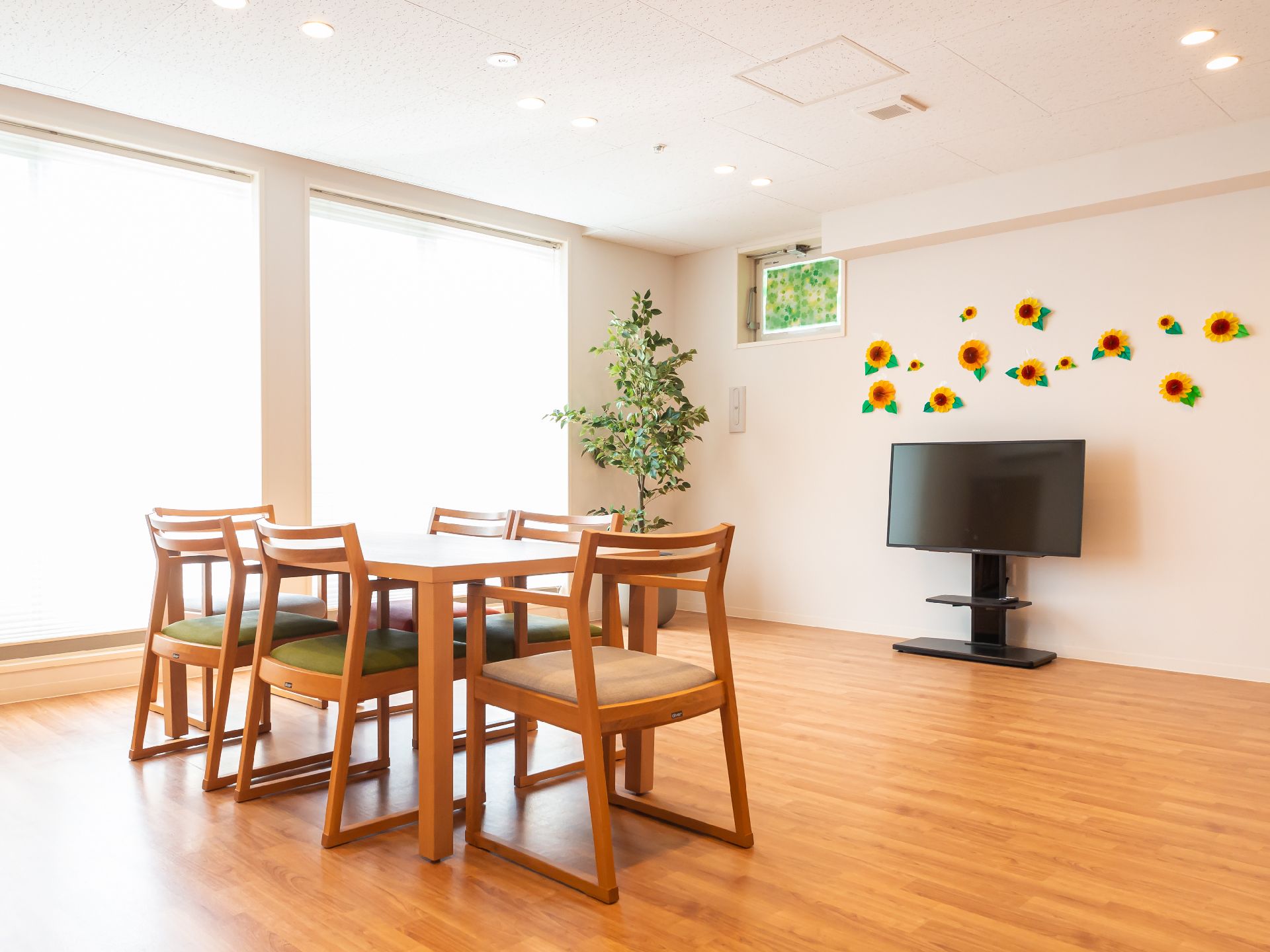 白い壁の部屋に配置された木製の机