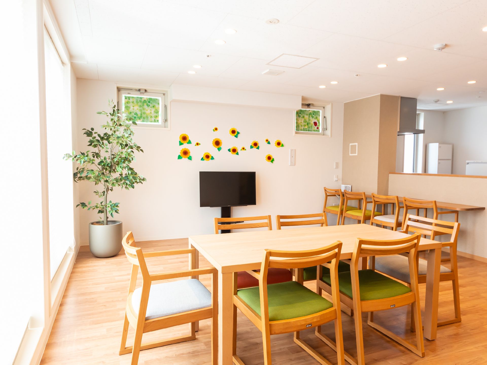 白い壁の部屋に置かれた木製の机と椅子