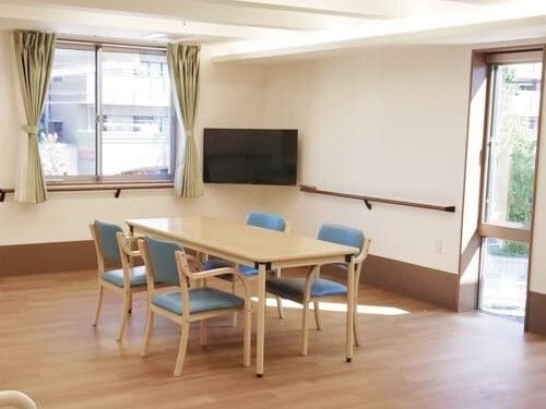 大きな壁掛けテレビが設置された食堂には木製のテーブルが置かれ、大きな窓が付いている。