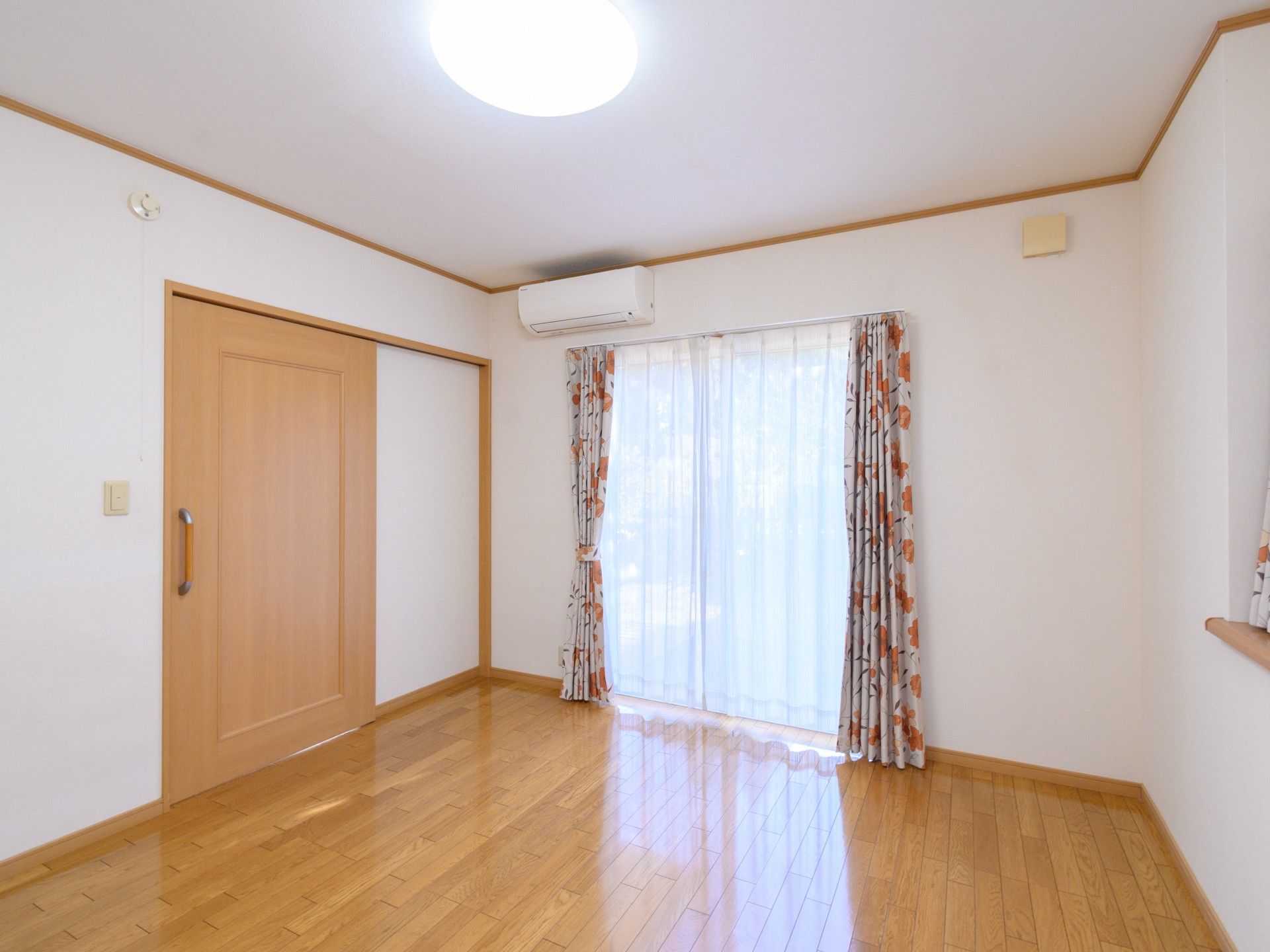 カーテン付きの大きな窓がある居室