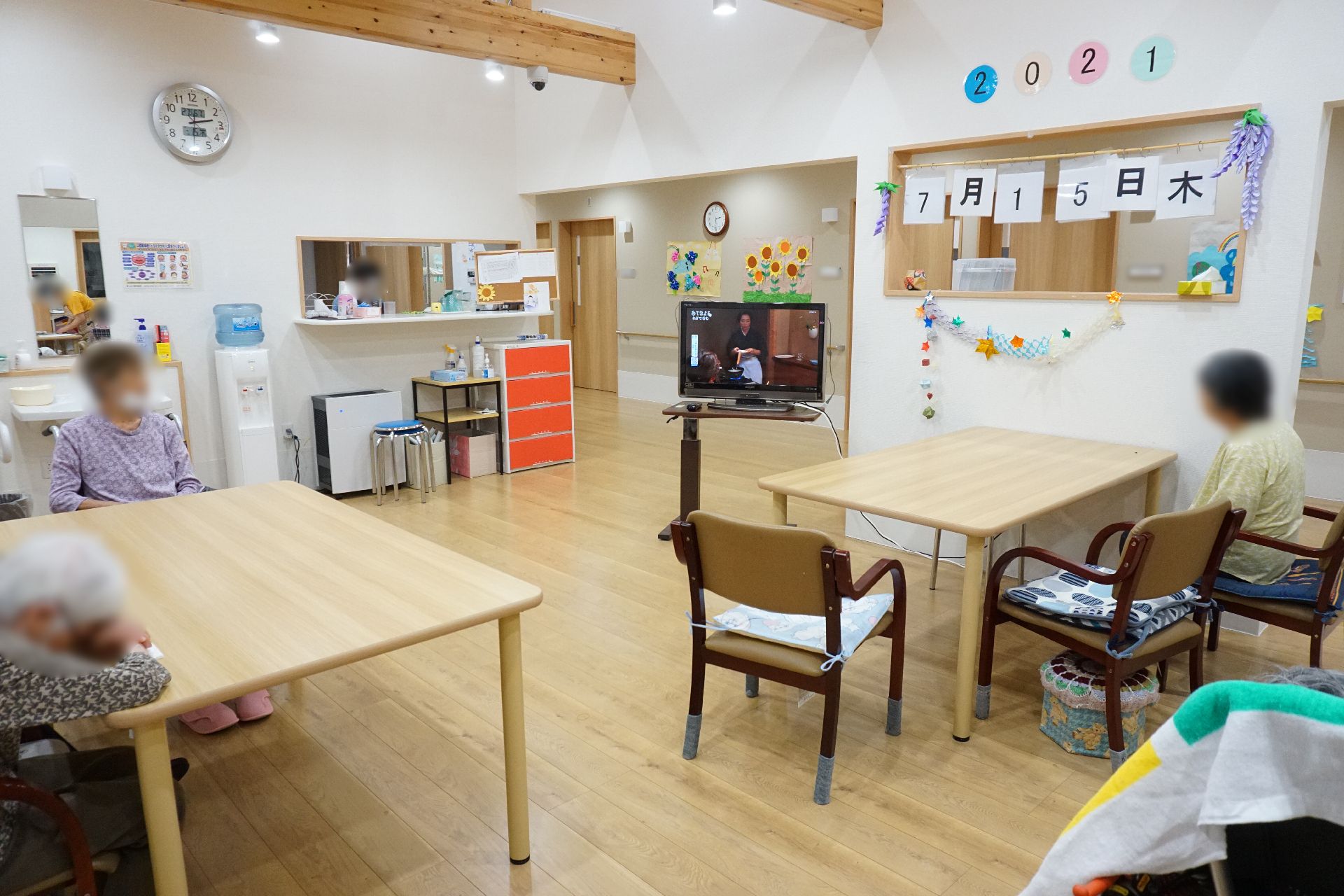 テレビが設置され、入居者が思い思いの時間を過ごしているリビング