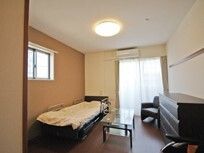 寝具付きのベッドやテーブル、タンスなどが置かれた部屋にはエアコンも設置されている。