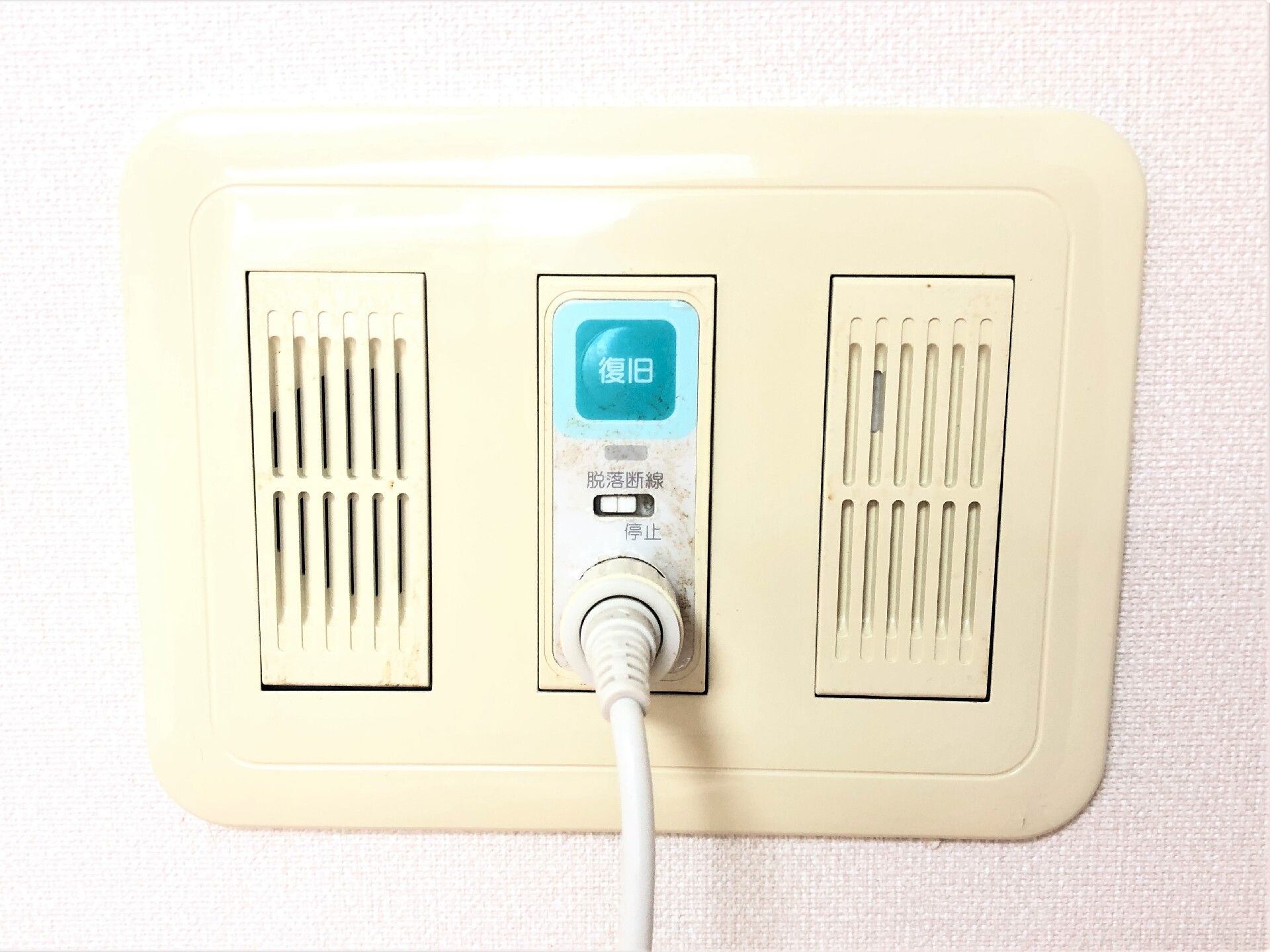 居室に付けられた緊急通報装置。「復旧」と書かれたグリーンのボタンが設置されている。