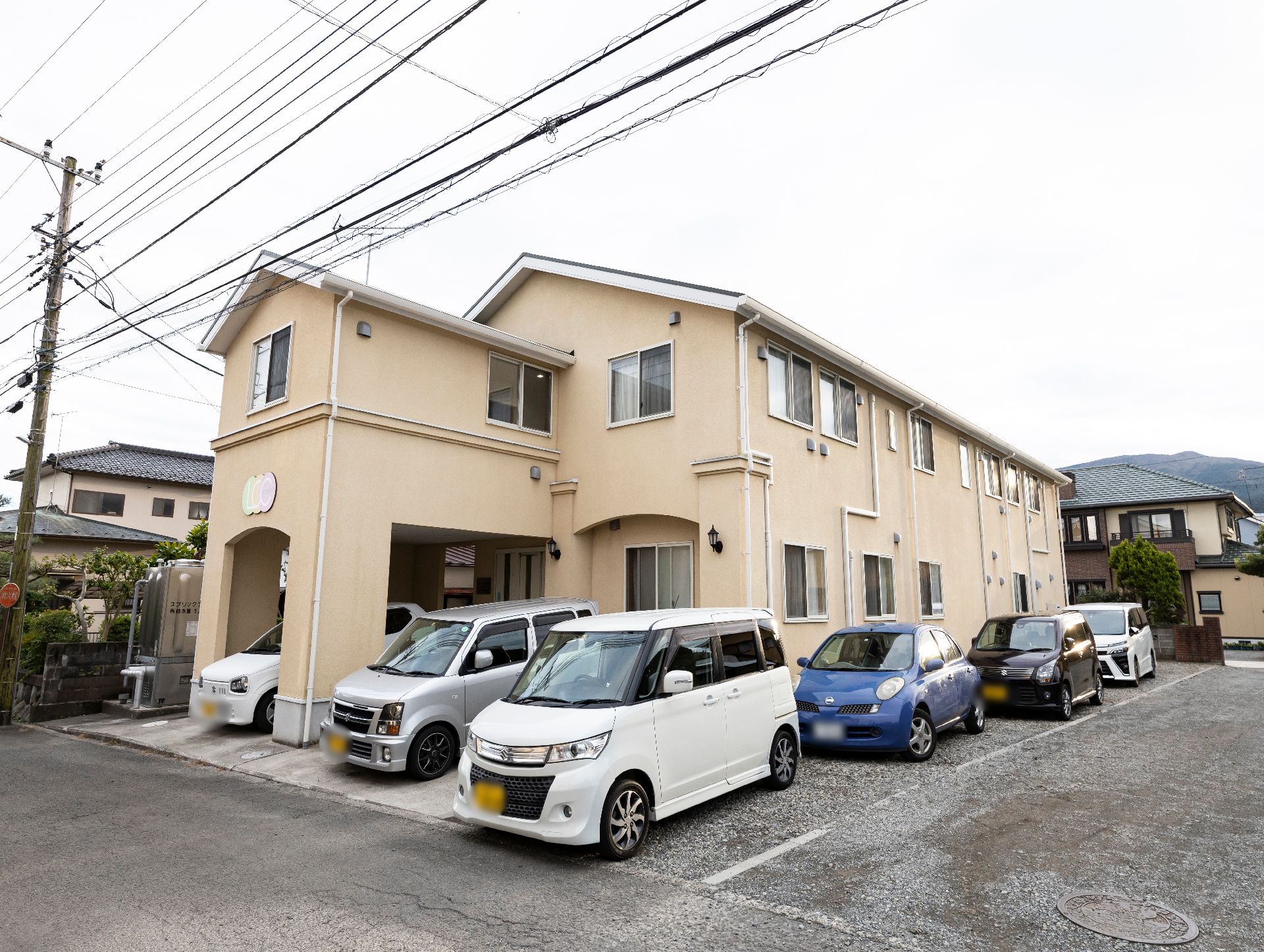 二階建てであり、クリーム色で塗られている介護施設の外観