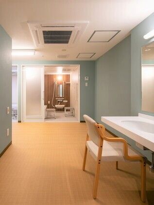 椅子が設置された洗面所が付いた脱衣所にはエアコンが付き、一人用の浴室が見える。