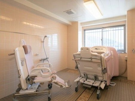 機械浴が完備され、介護度が高い人にも対応しているタイル張りの浴室。シャワーも付いている。