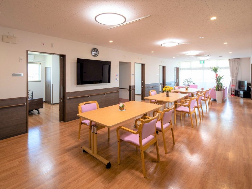 テレビやダイニングテーブルが設置された食堂の周りには、居室があり、ドアが開いている。