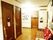 一画に赤いカバーをかけたソファーを置いた、他の部屋へのドアが並ぶ廊下