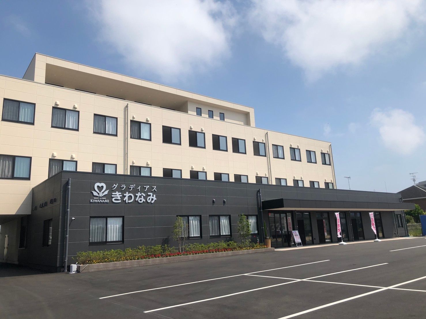 白をメインとした建物は明るい雰囲気で、１階部分は黒く、外壁にはホーム名が書かれている。