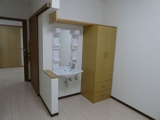 フローリングの部屋には洗面所やクローゼットが置かれ、洗面所は車いす対応のデザイン。