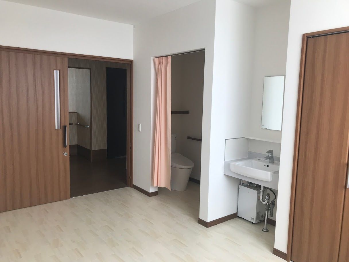カーテンで仕切られたトイレと洗面台が設置された居室