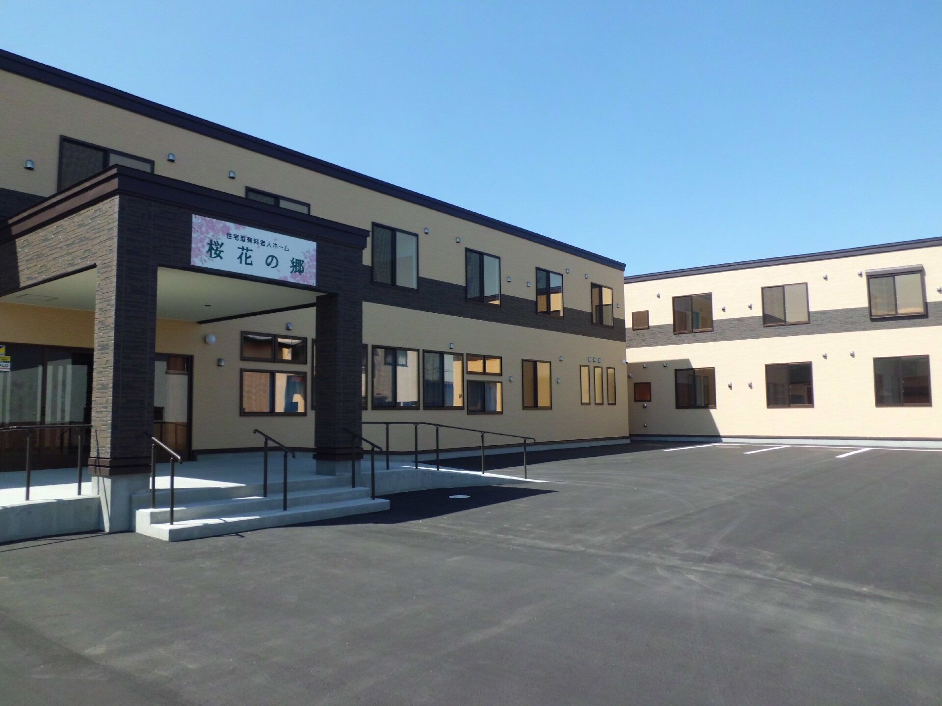 エントランスに手すり付きの階段とスロープが設置された建物