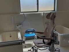 車いす型のリフトが設置された浴室内には一人用の浴槽が二つ設置され、大きな窓が付いている。