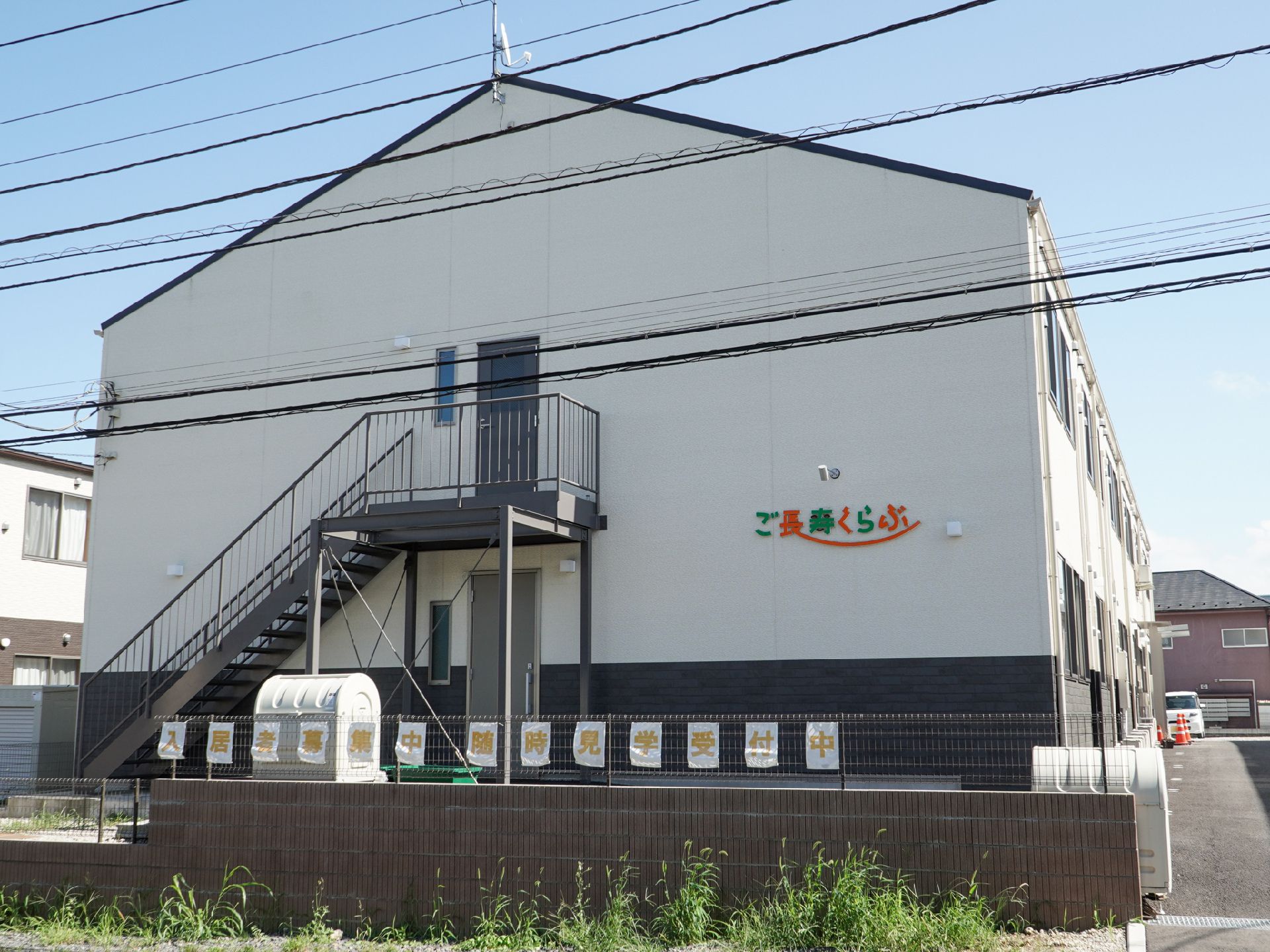 ２階建ての白色を基調とした清潔感のある外観の老人ホーム