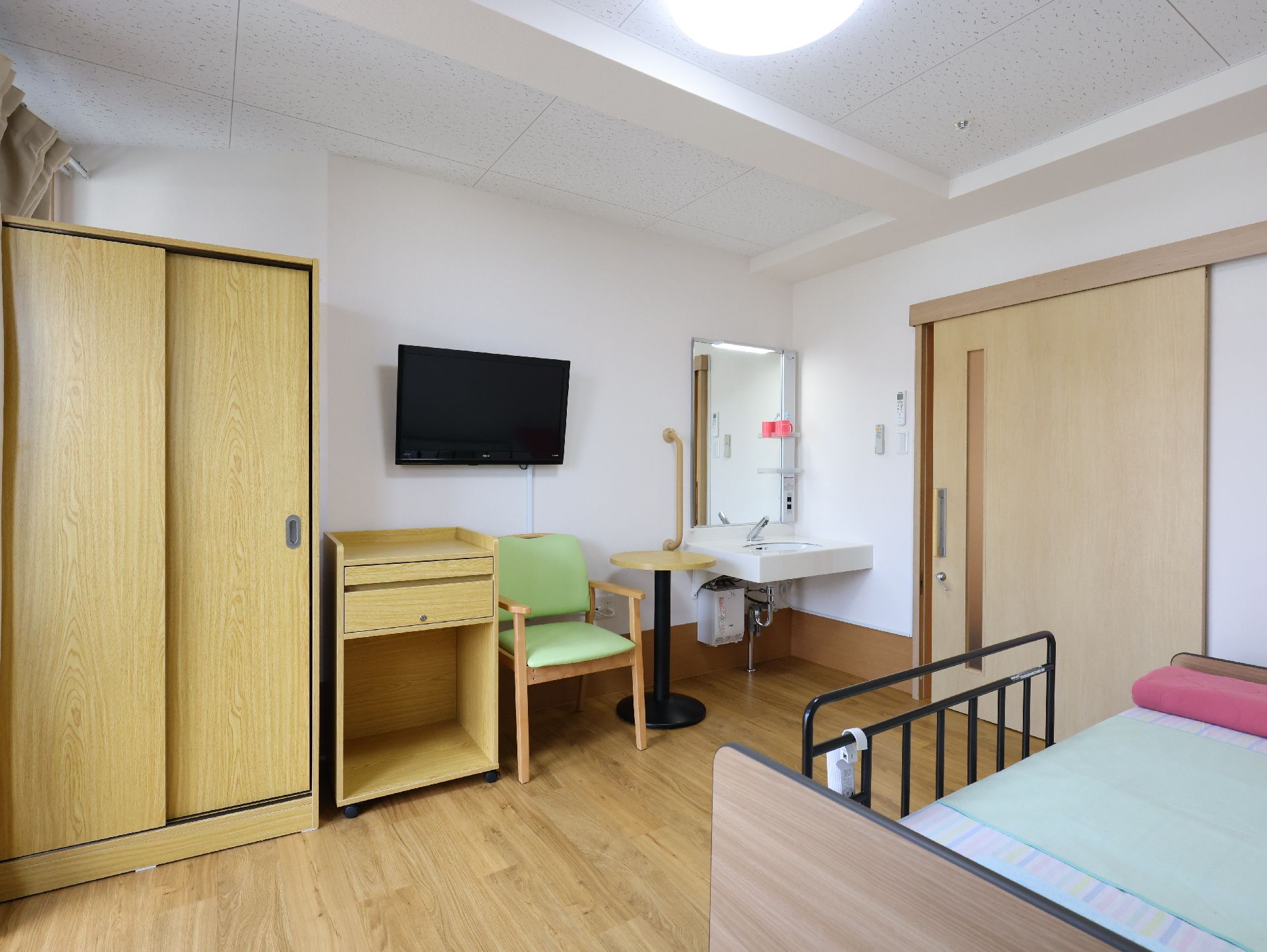 介護ベッドが置かれ、引き戸のドアが設置されている居室