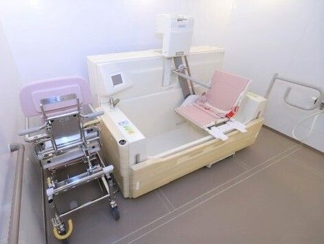 機械浴が完備され、介護度が高い人にも対応している明るい浴室。手すりや浴室用の車いすも付いている。