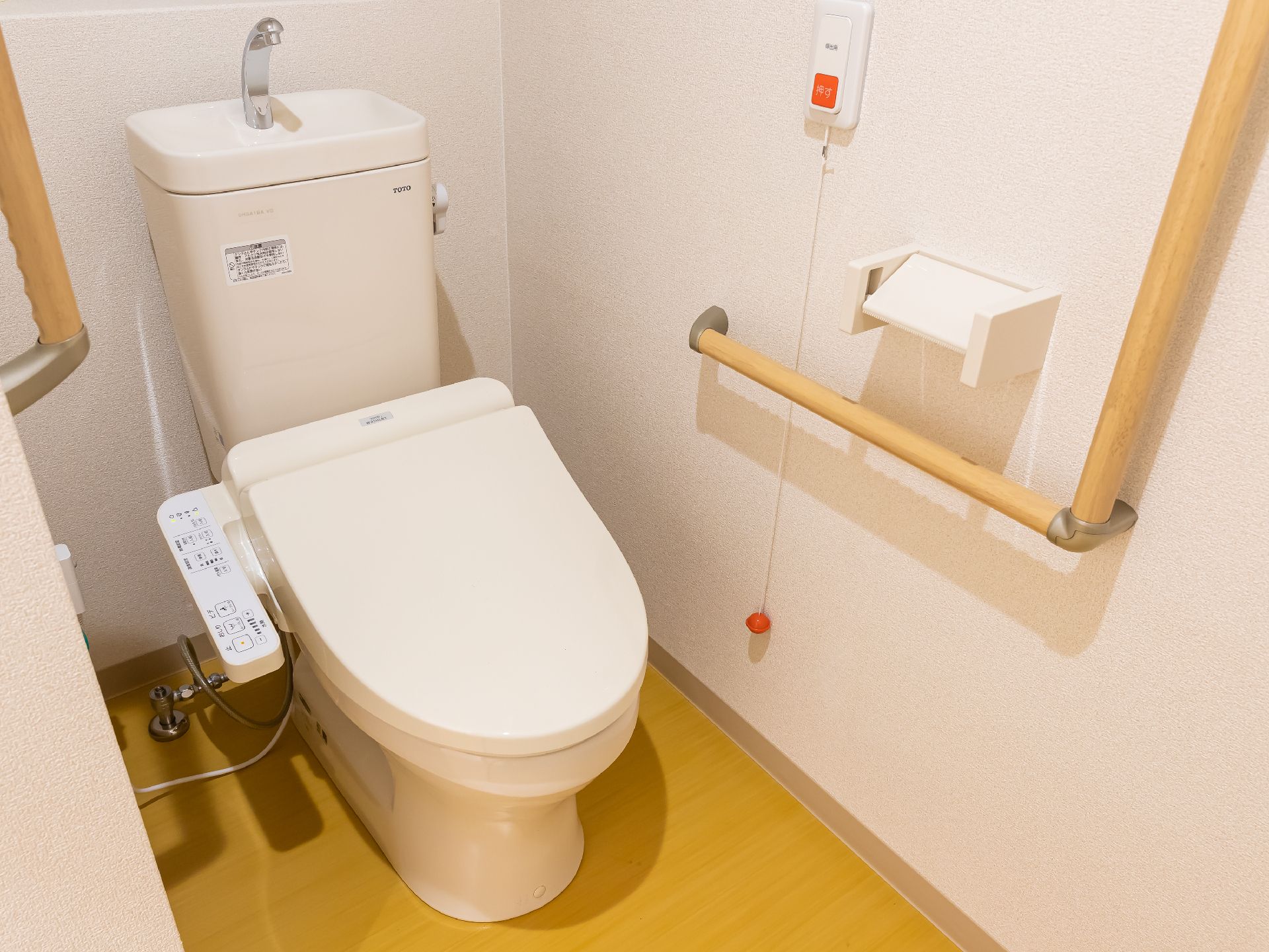 高齢者でも楽に座ることが可能な、手すりのついたトイレ
