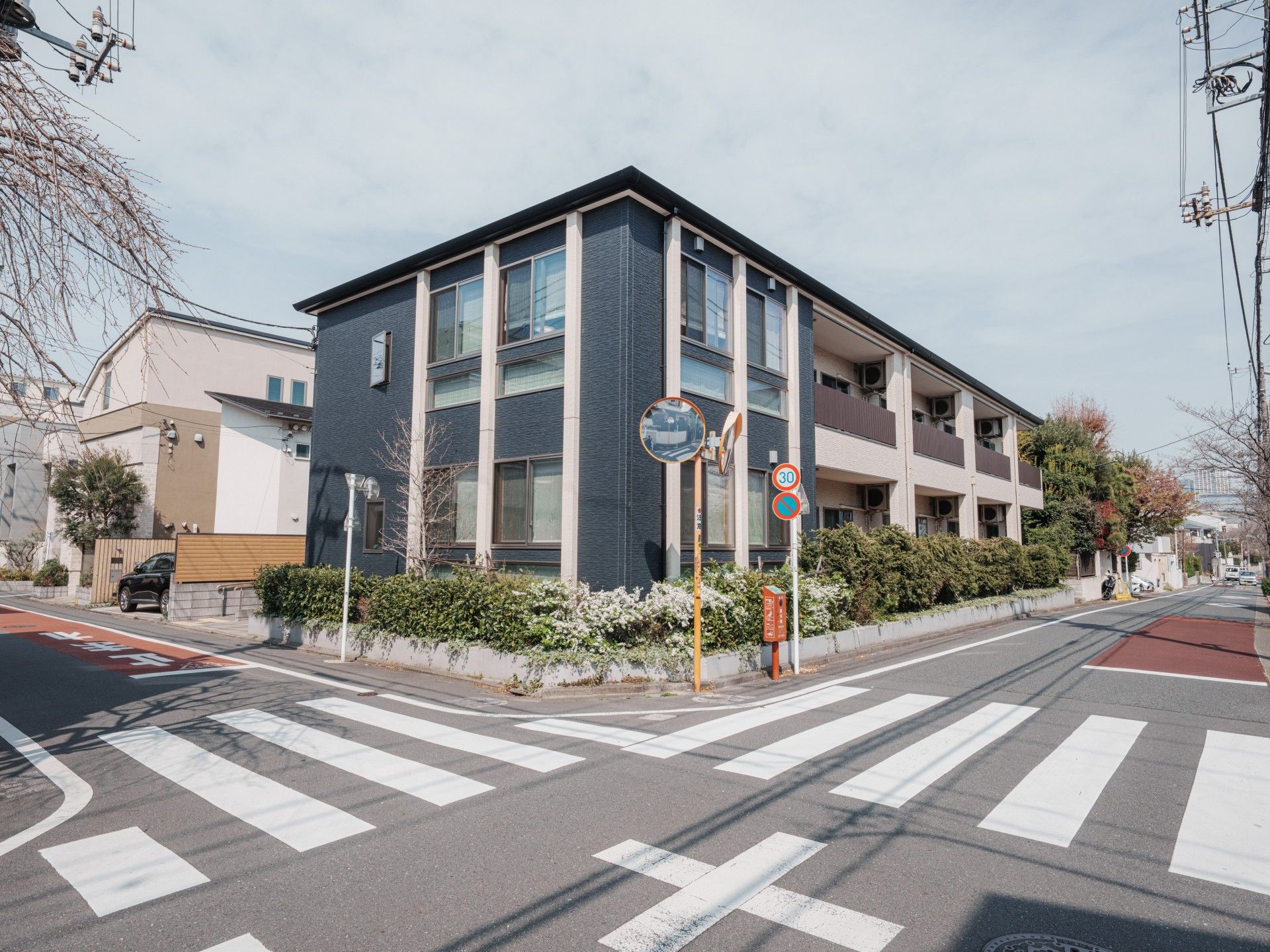 車いすの高齢者と手を握りながら話す介護スタッフの様子。施設内での会話の場面