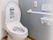 呼び出しボタンが付いたトイレには手すりが付き、全体的に白で当いるされているが壁の一面はブルー。