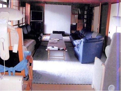 ブルーのソファや長いローテーブルが置かれた部屋にはテレビもあり、スクリーンもセットされている。