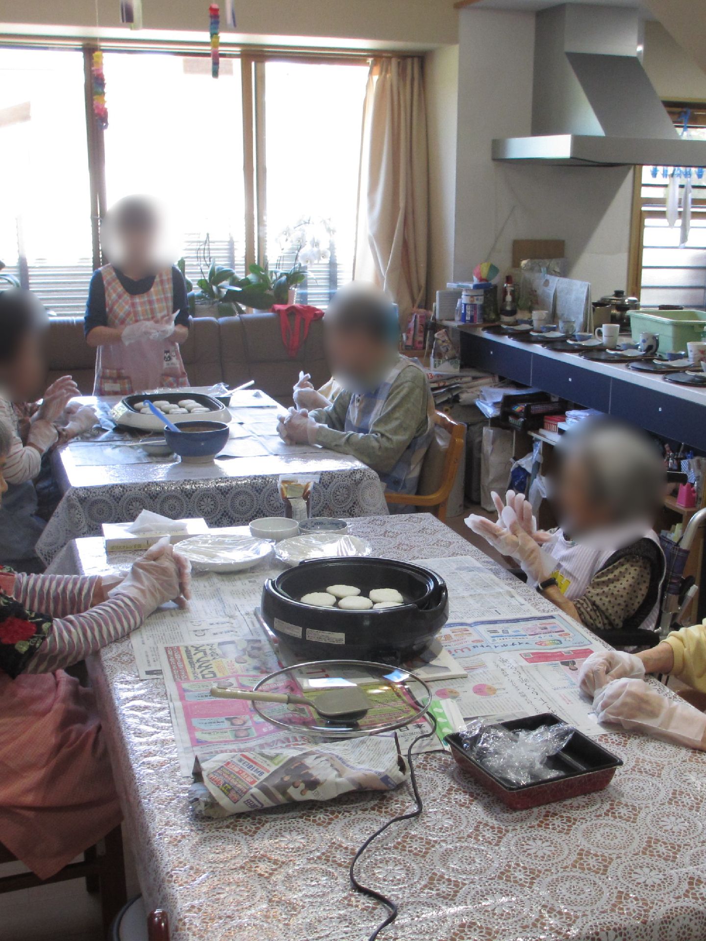 瓦屋根が付いた日本風の家屋が奥にあり、敷地内には大きな木が植えられた庭があり、高齢男性が一人で落ち葉集めをしている。