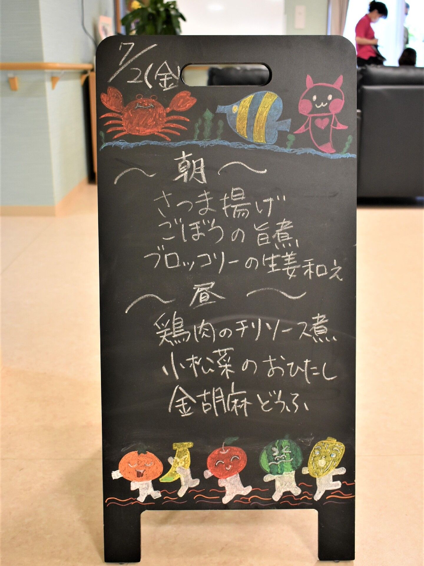 カニや魚、豚などのイラストが枯れた黒い黒板には、その日の朝と昼のメニューが書かれている。奥にはスタッフの姿も見える。