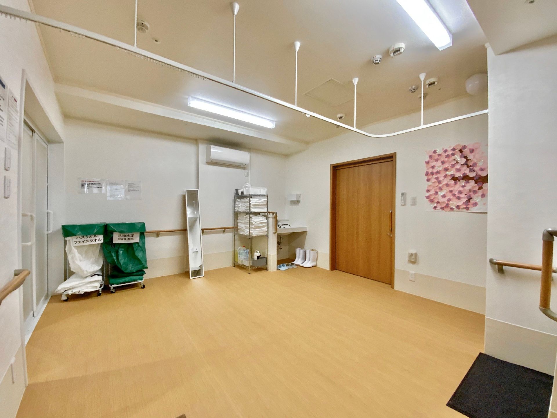 壁に桜の絵の作品が飾られている脱衣場