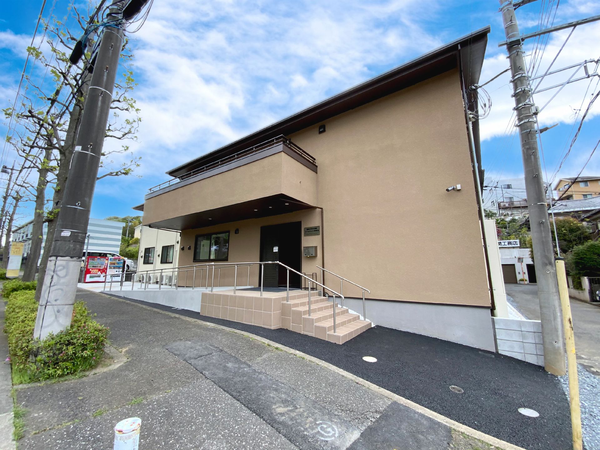 玄関前に手すり付きの階段とスロープが設置された建物