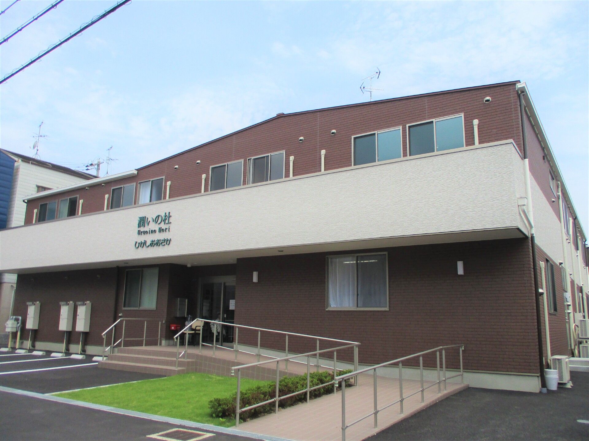 二階建ての施設外観。駐車場から入り口までは階段のほかスロープも設置されている。