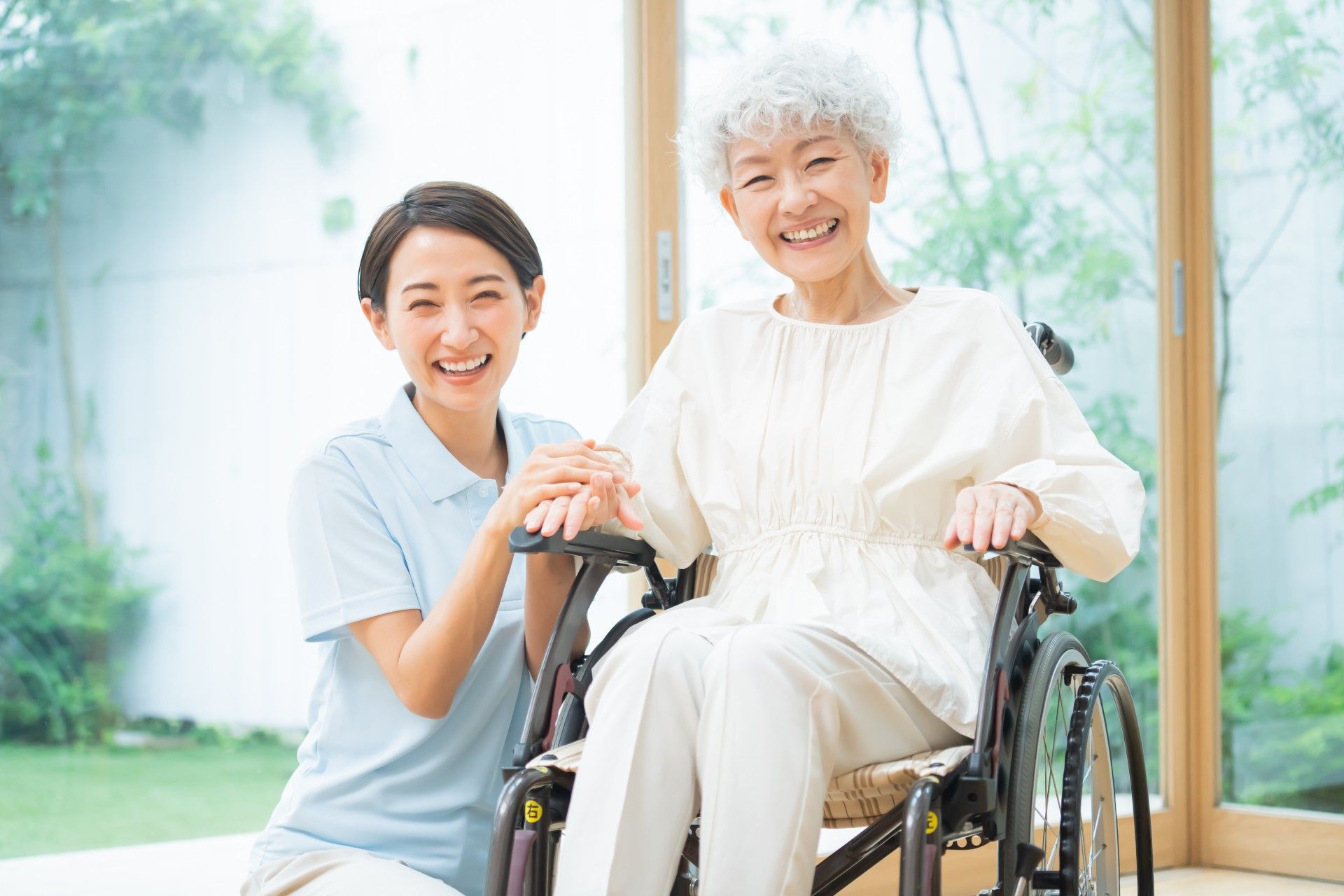 ベッドに寝た状態で食事を摂っている女性と介助しているスタッフの様子