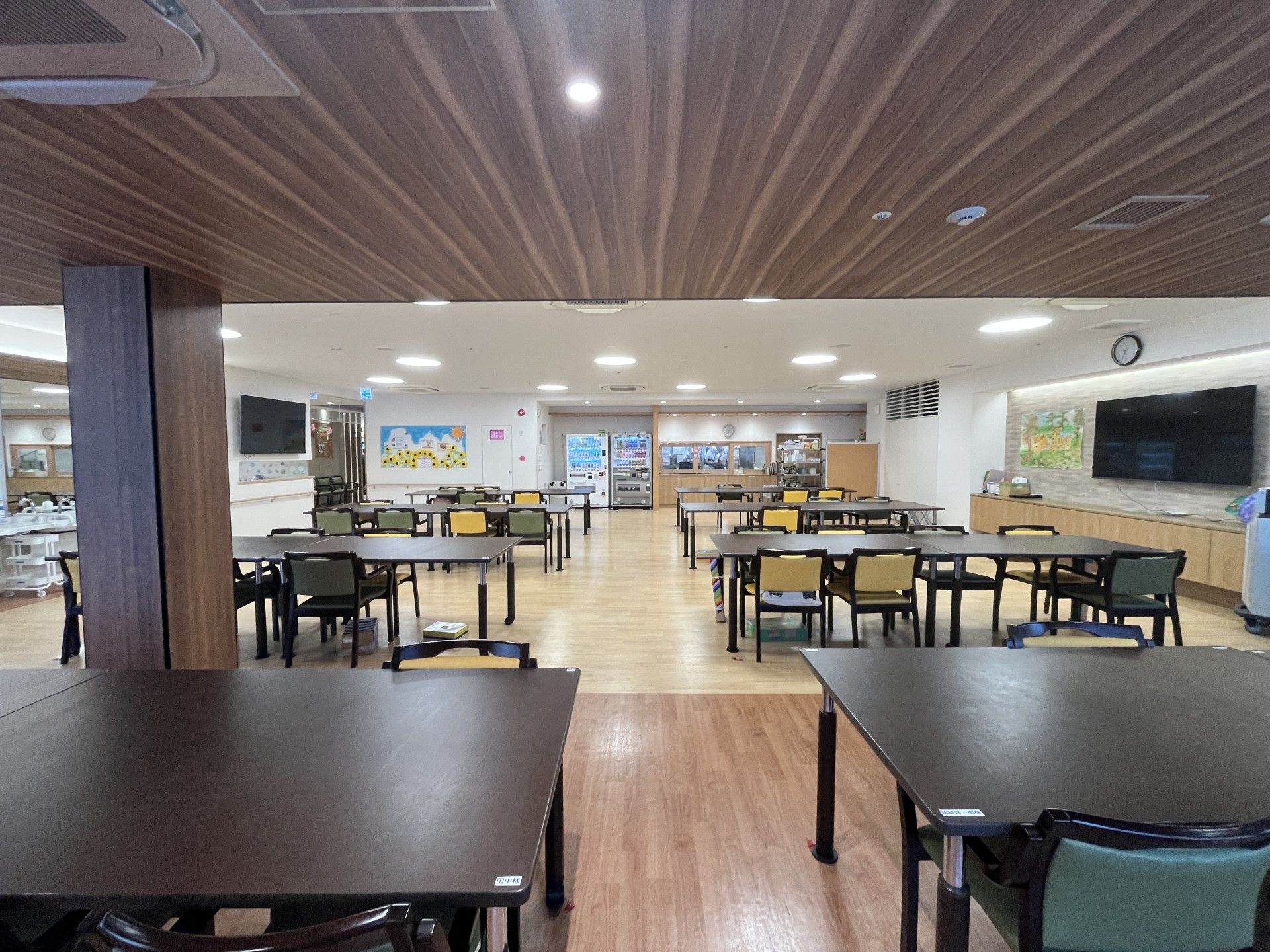 車椅子に乗った笑顔の高齢女性と介助をする女性ヘルパー