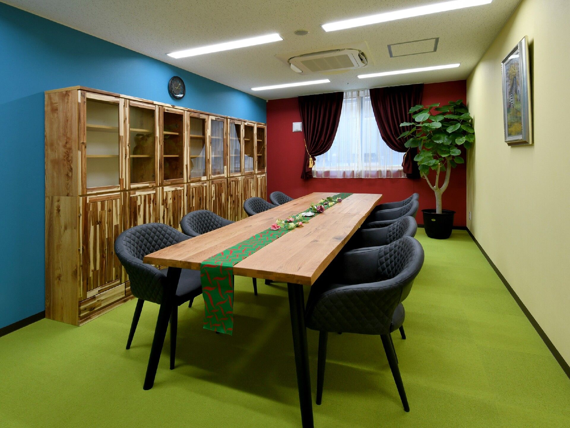 内装に光の三原色を使い、木肌が強調された家具を配置した部屋