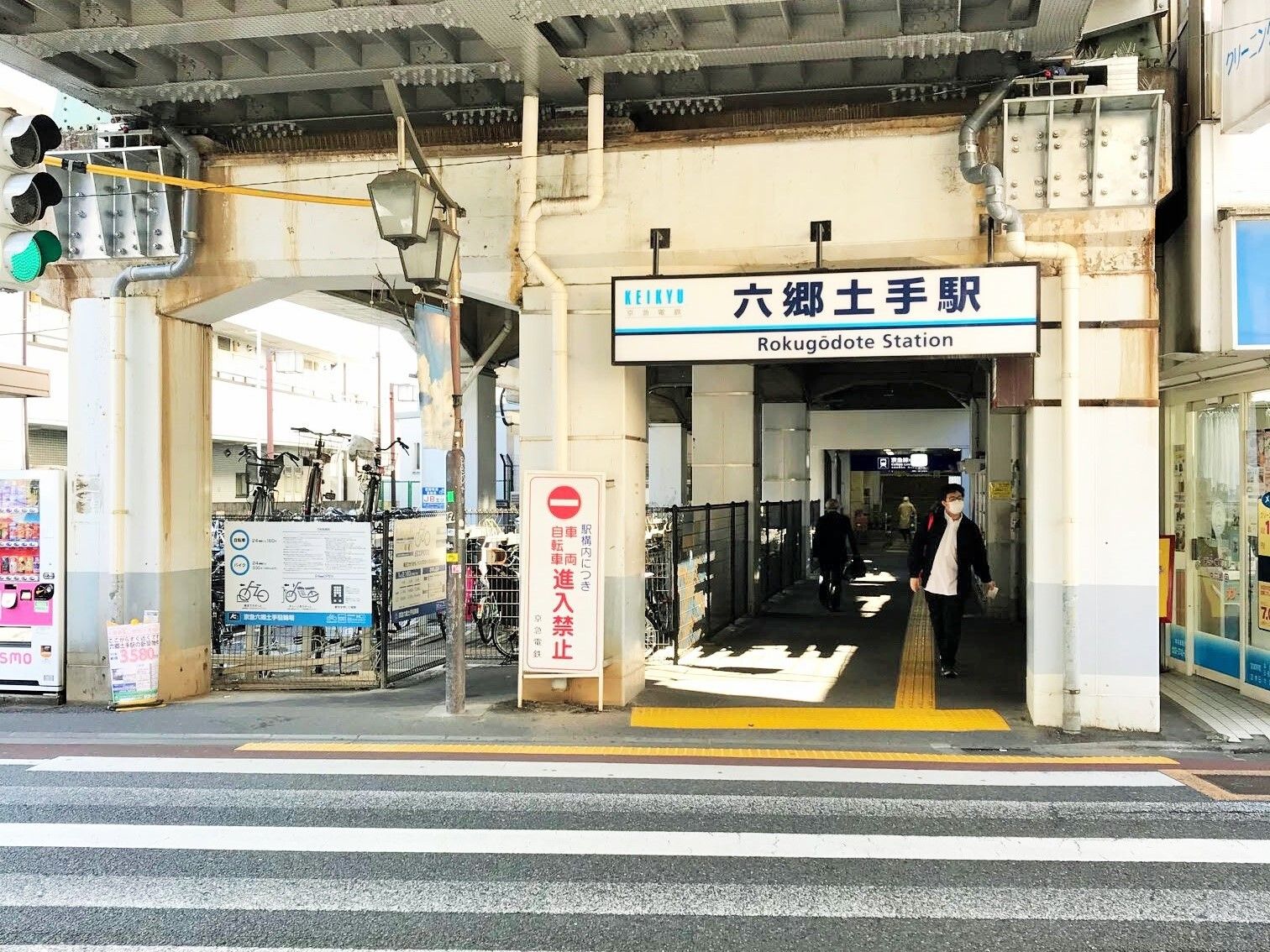 「六郷土手駅」と書かれた看板が設置され、すぐそばにはたくさんの自転車が止まっている駐輪場がある。
