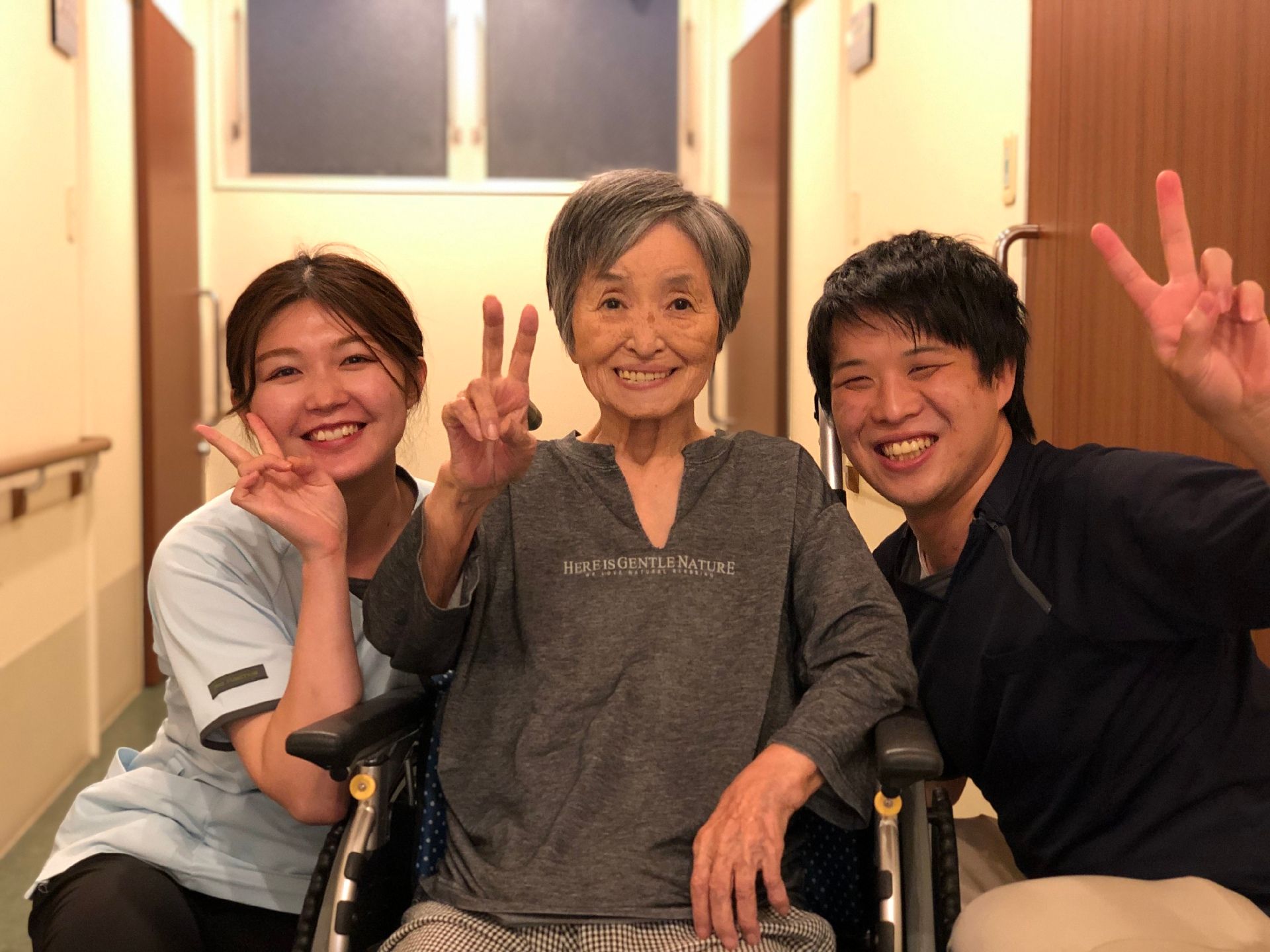 車椅子に座っている高齢女性と向き合う女性ヘルパー