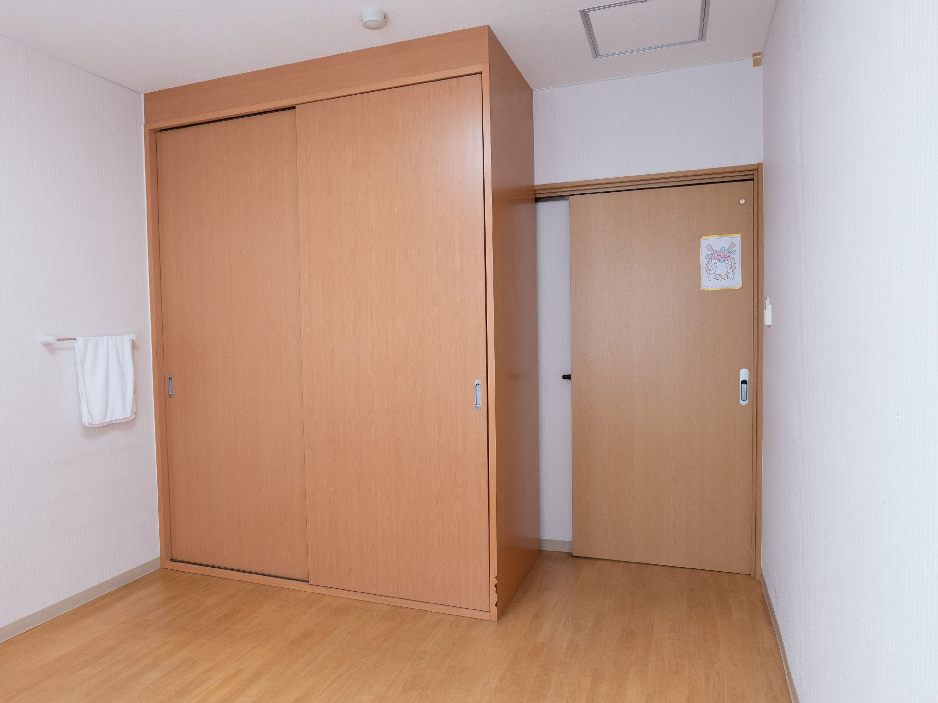 窓から日差しが注ぎ、介護ベッドや椅子が置かれている居室