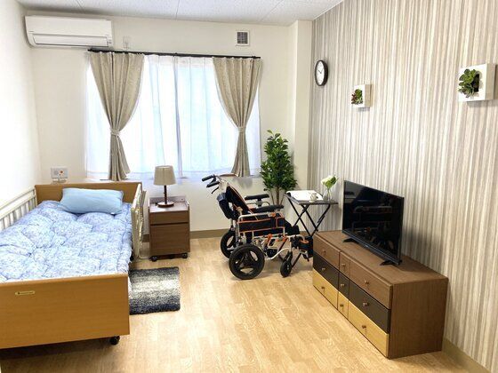 壁紙が印象的なワンルームタイプの部屋の様子。施設内の居室の全景写真