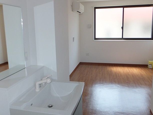 フローリングの部屋にはエアコンが設置され、大きな鏡が付いた洗面所もあり、家具や家電は置かれていない。
