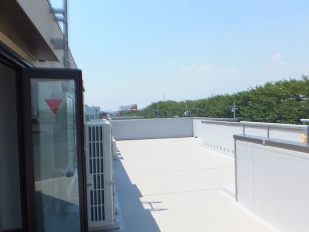 周辺に緑が多く、屋上には何も置かれていない。日当たりのいい屋上からは周辺を見渡すことができる。