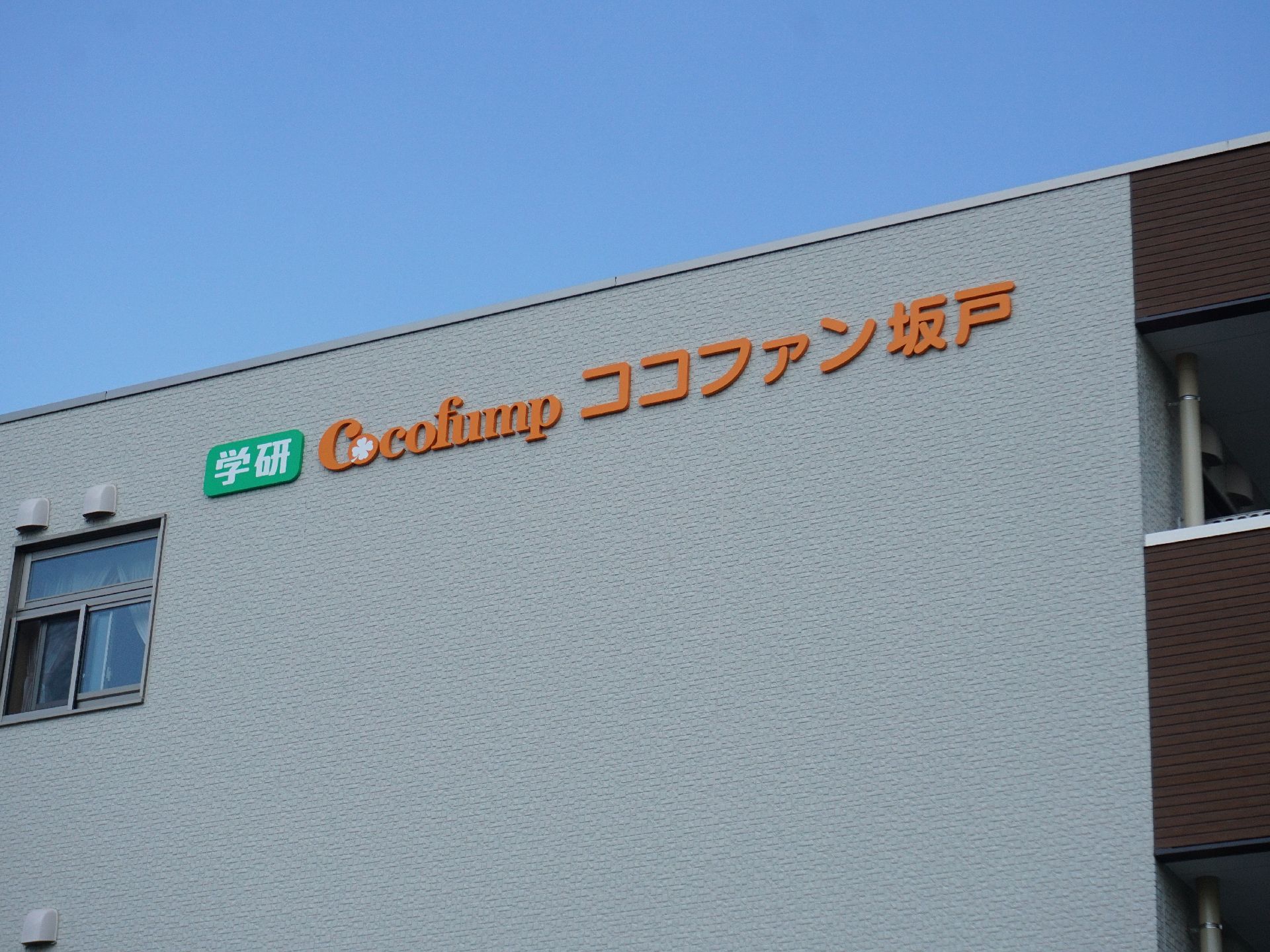 施設の外壁にオレンジの文字で書かれている施設の名称とロゴ
