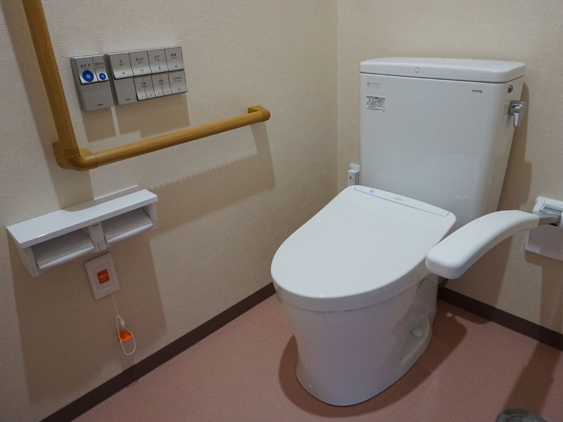 壁に大きな手すりが取り付けられ、完全にバリアフリー化されているトイレ