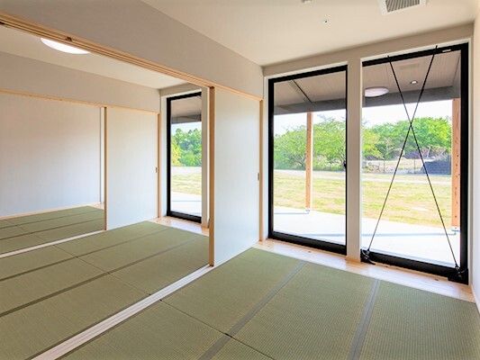 広い庭園を眺めることができる大きな窓がたくさんついた畳敷きの部屋は、障子で３つに仕切ることができる。