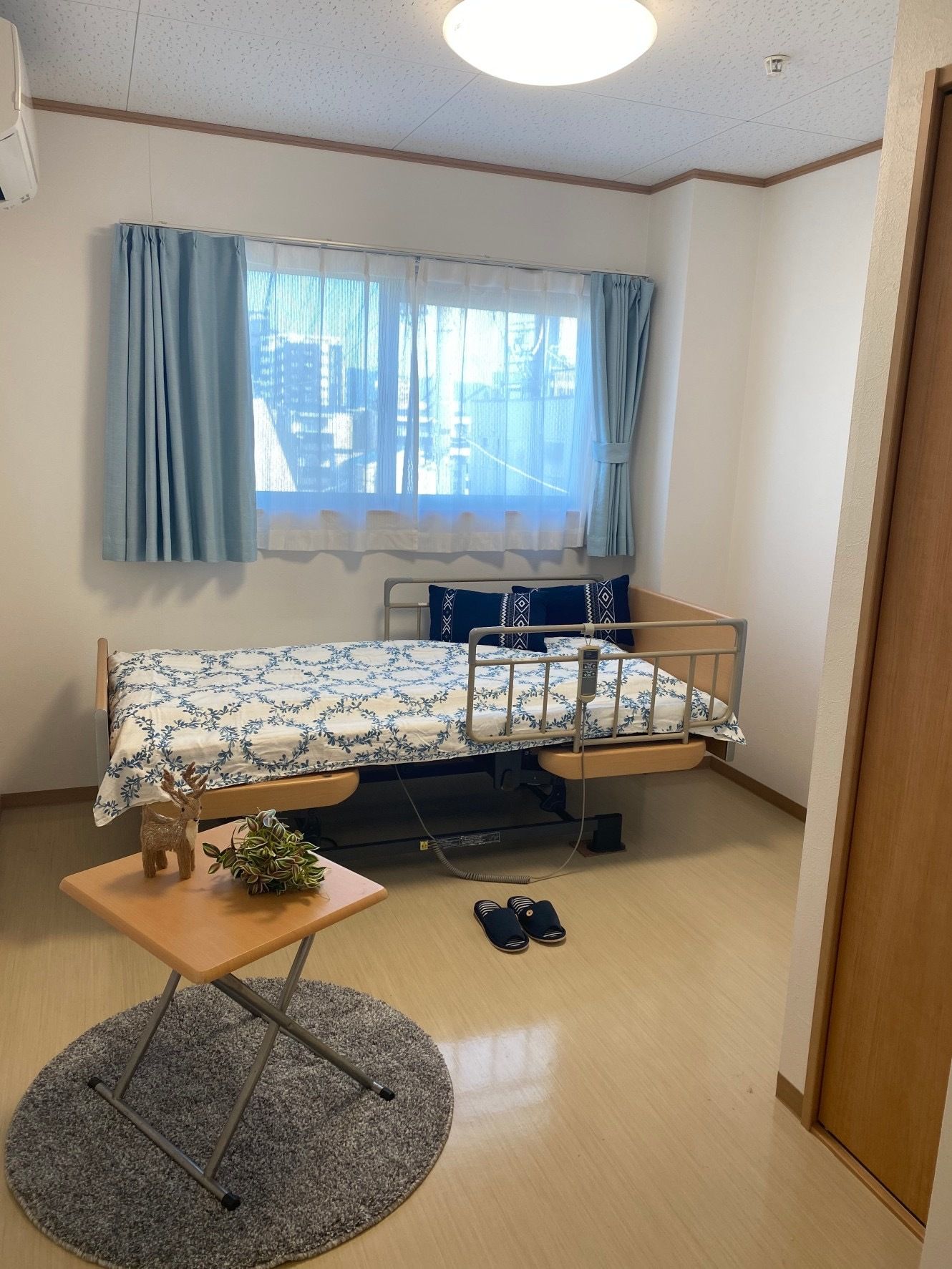 大きな窓があり明るい雰囲気。居室には、ベッドやテーブルだけでなくエアコンもついている。