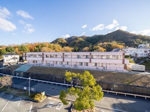 周辺を緑に囲まれた２階建ての建物は白を基調としていて、少し小高い場所にある。