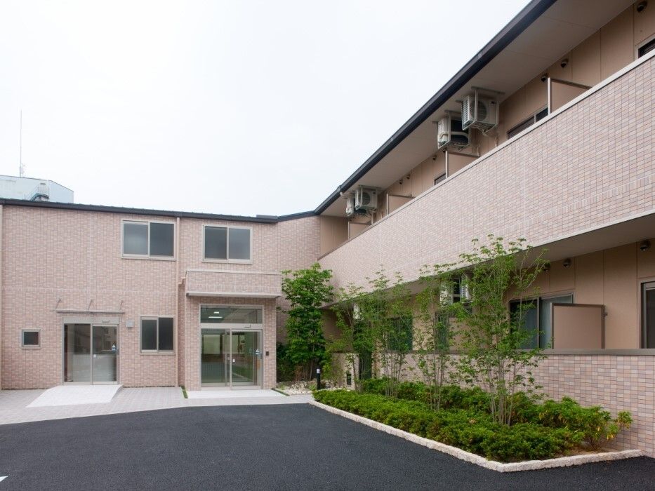 各フロアにベランダがあり、エル字型の２階建ての建物の周りには草木が植えられ、玄関先には段差はない。