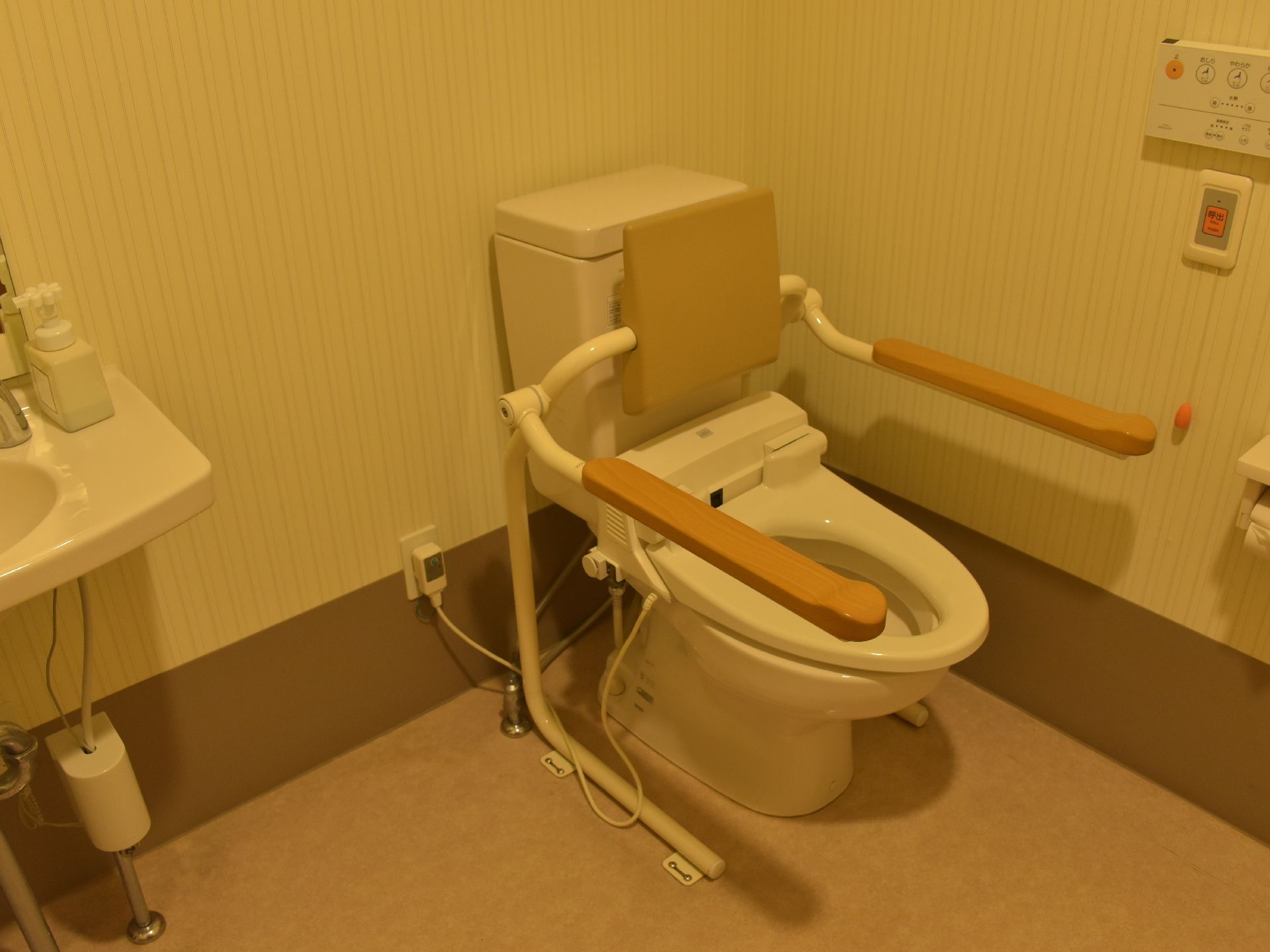 トイレの便座には手すりと背もたれがついていて、体の不自由な方も安全に利用できる。ウォシュレットも完備されている。